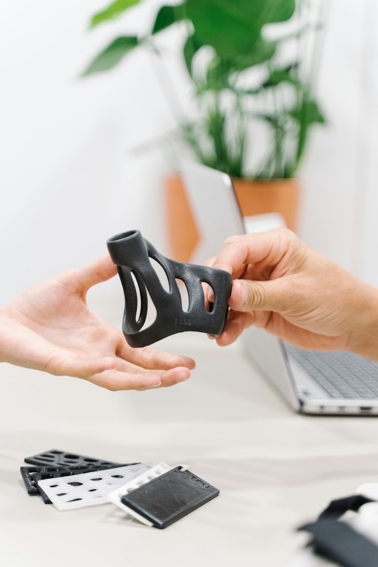 Hand holding a black 3D printed part